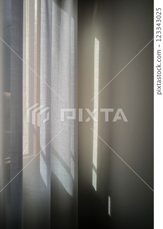 柔和的晨光映照在安靜的蕾絲窗簾上 123343025