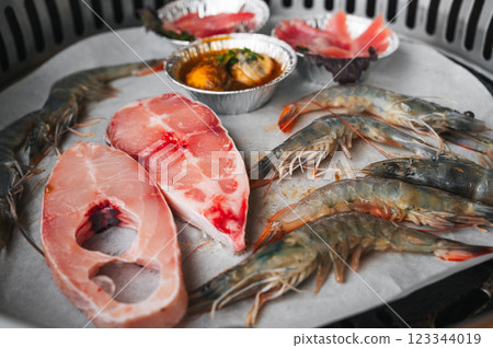 Seafood is grilled at buffet in Asian restaurant in Asia in Vietnam. Fish and shrimp are fried on stove 123344019