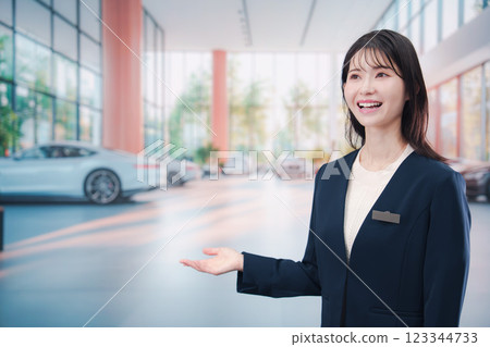 一名年輕女子在汽車經銷店為顧客服務 123344733