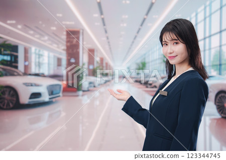 一名年輕女子在汽車經銷店為顧客服務 123344745