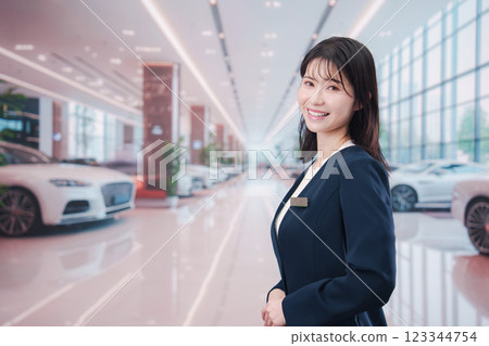 A young woman serving customers at a car dealership 123344754