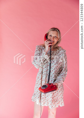 woman holding receiver from retro phone for conversation 123344809