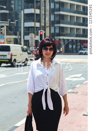 Nicely dressed woman on a sunny hot day in the center of a busy city 123345291