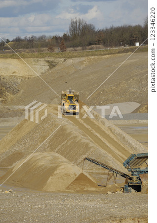 A yellow wheel loader is working in gravel pit 123346220