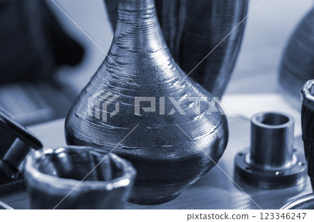 Objects printed with a 3D printer from a filament of molten metal on a table. Objects printed with a 3D printer from a filament of molten metal on a table. 123346247