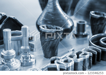 Objects printed with a 3D printer from a filament of molten metal on a table. Objects printed with a 3D printer from a filament of molten metal on a table. 123346253