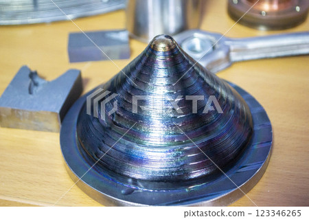 Objects printed with a 3D printer from a filament of molten metal on a table. Objects printed with a 3D printer from a filament of molten metal on a table. 123346265