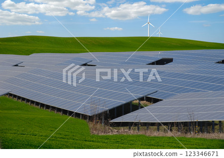 Rows of solar panels, wind turbine and green nature Rows of solar panels, wind turbine and green nature 123346671