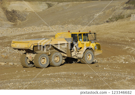 Yellow dump truck working in gravel pit Yellow dump truck working in gravel pit 123346682