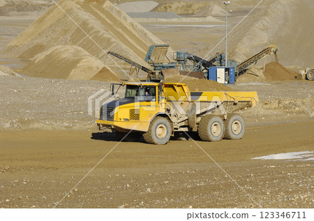 Yellow dump truck working in gravel pit Yellow dump truck working in gravel pit 123346711