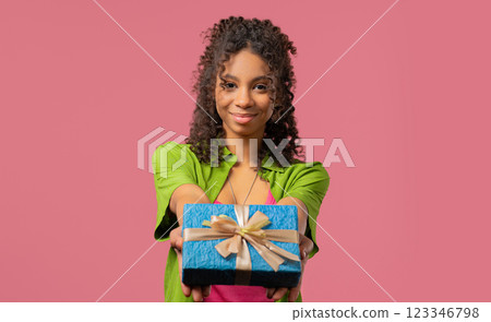 Happy teenager girl gift box on pink background. Young lady smiling, gives you Happy teenager girl gift box on pink background. Young lady smiling, gives you 123346798