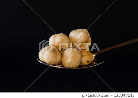 Natural nuts in a spoon on a contrasting background Natural nuts in a spoon on a contrasting background 123347212