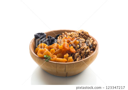 Prunes, dried apricots and nuts in a wooden bowl on a white background 123347217