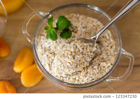 Healthy raw oatmeal in bowl on wooden table 123347230