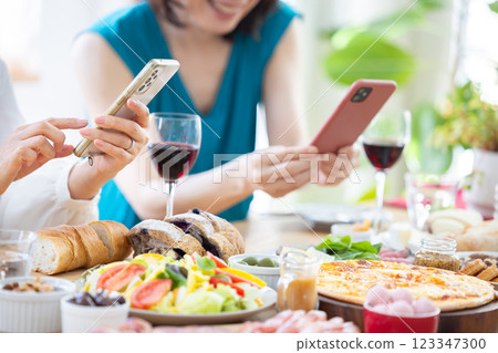 一名女子正在拍攝派對食物的照片 123347300
