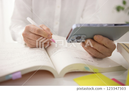 The hands of a middle-aged woman studying 123347303