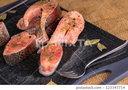 Salmon steaks with herbs and black pepper 123347714