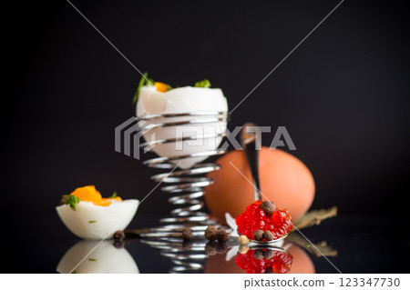 delicacy with red caviar and boiled egg for breakfast, isolated on black background 123347730