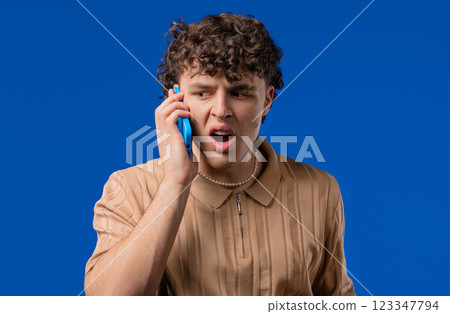 Angry handsome man quarreling, screaming talking on mobile phone. Guy in stress Angry handsome man quarreling, screaming talking on mobile phone. Guy in stress 123347794