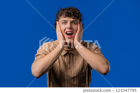 Shocked curly haired man glad, screaming WOW. Impressed guy, unbelievable Shocked curly haired man glad, screaming WOW. Impressed guy, unbelievable 123347795