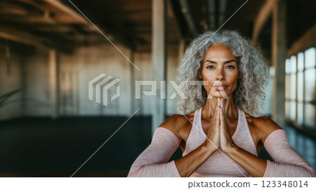 Portrait of an elderly woman exercising in a bright room, concept of wellness activities supporting an active lifestyle for seniors and improving health and well-being 123348014