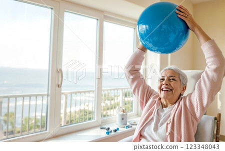 exercise with fitness ball, elderly happy woman lifting ball over head doing exercises, concept of active rehabilitation of older people 123348043