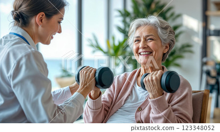 Elderly woman lifting dumbbells under guidance, personal coaching by a physiotherapist, supportive therapy providing safe and active exercise for older adults 123348052