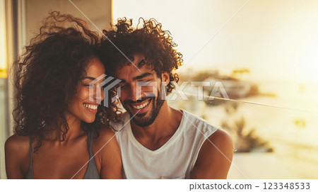 Happy laughing newlyweds sitting on hotel balcony overlooking ocean, honeymoon time on Mediterranean coast, concept of joint vacation and family travel Happy laughing newlyweds sitting on hotel balcony overlooking ocean, honeymoon time on Mediterranean coast, concept of joint vacation and family travel 123348533
