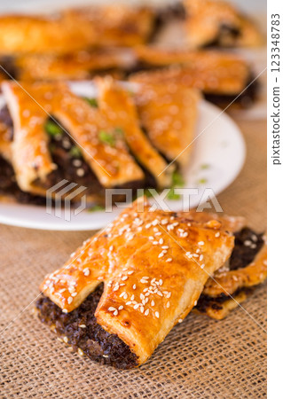 Golden puff pastries with mushroom filling and sesame seeds 123348783
