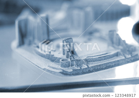 Object printed on a 3D printer from molten plastic powder close-up. Model printed on 3D printer from melted polyamide powder. New additive manufacturing 3D printing. Multi Jet Fusion MJF technology Object printed on a 3D printer from molten plastic powder close-up. Model printed on 3D printer from melted polyamide powder. New additive manufacturing 3D printing. Multi Jet Fusion MJF technology 123348917