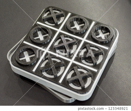 Art object toy Tic Tac Toe printed on 3D printer from white and black plastic. Model created on 3d printer and lying on table. FDM. Concept 3D Printing. Additive modern new progressive technologies Art object toy Tic Tac Toe printed on 3D printer from white and black plastic. Model created on 3d printer and lying on table. FDM. Concept 3D Printing. Additive modern new progressive technologies 123348921