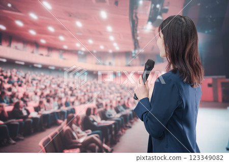 一位年輕女子在大批觀眾的大廳裡舉辦音樂會 123349082