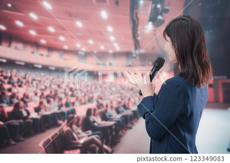 A young woman hosting a concert in a hall with a large audience 123349083