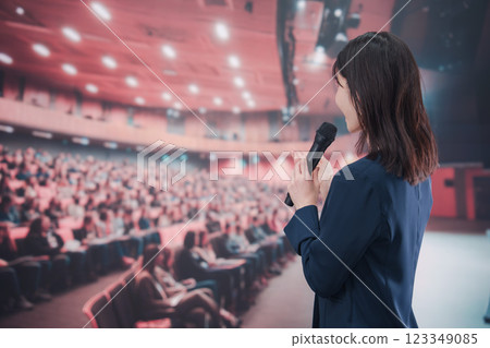 一位年輕女子在大批觀眾的大廳裡舉辦音樂會 123349085