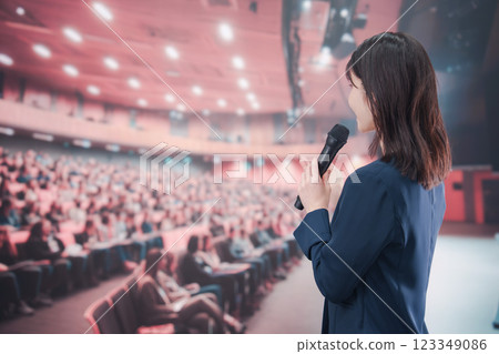 A young woman hosting a concert in a hall with a large audience 123349086