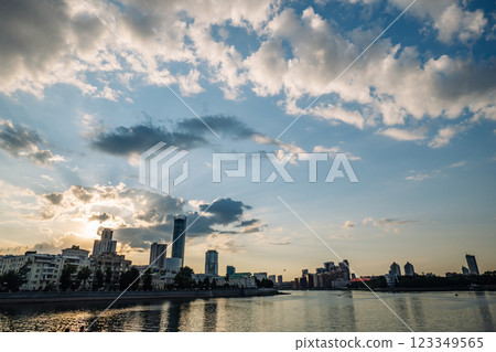 Modern buildings along the iset river in yekaterinburg, russia, create a stunning cityscape under a dramatic sunset sky with beautiful clouds 123349565