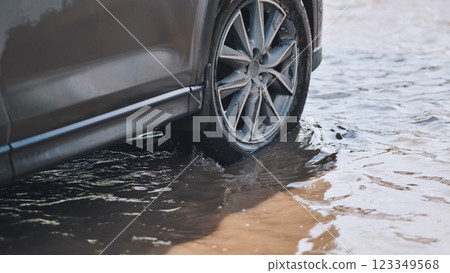 Flooding roadway with vehicle navigating deep water amid severe rainfall and storm conditions 123349568