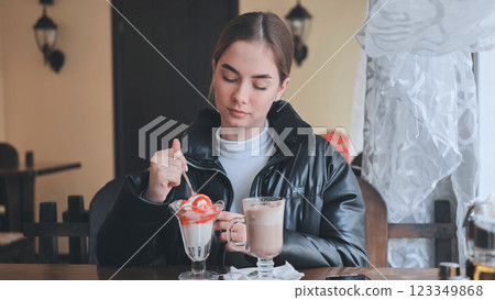 Person enjoying sweet treats, sipping warm beverage at rustic cafe table Person enjoying sweet treats, sipping warm beverage at rustic cafe table 123349868