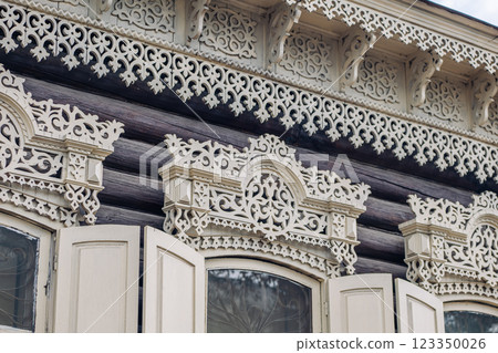 Intricate carvings embellish the window frames of a historic wooden house, showcasing the rich heritage of russian architecture 123350026