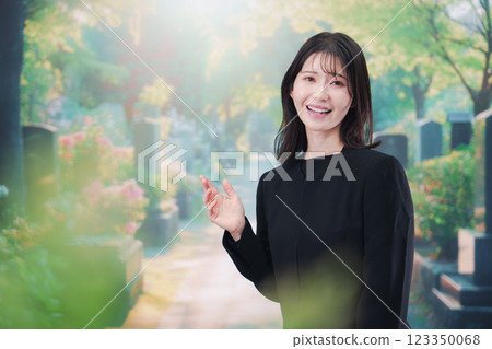 A woman in mourning clothes visiting a grave A woman in mourning clothes visiting a grave 123350068