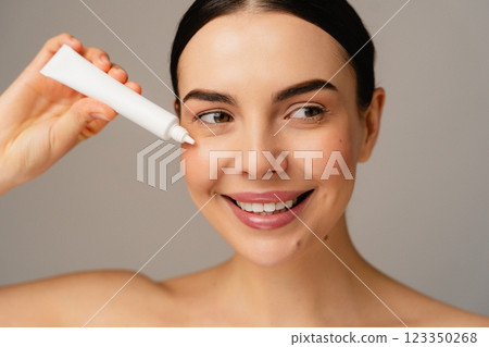 Smiling Person Applies Cream for Skincare with Radiant and Healthy Skin Smiling Person Applies Cream for Skincare with Radiant and Healthy Skin 123350268