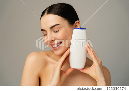 Smiling Woman Enjoying Skincare Product on Neutral Background Smiling Woman Enjoying Skincare Product on Neutral Background 123350274