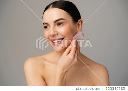 Smiling Bare Woman Demonstrating Skincare with Blotting Paper Smiling Bare Woman Demonstrating Skincare with Blotting Paper 123350285