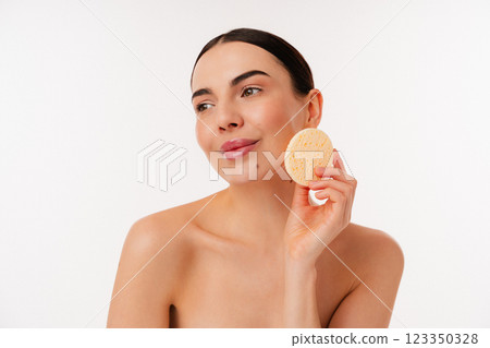 Person Enjoying Skincare Routine with Spa Sponge on Face Person Enjoying Skincare Routine with Spa Sponge on Face 123350328
