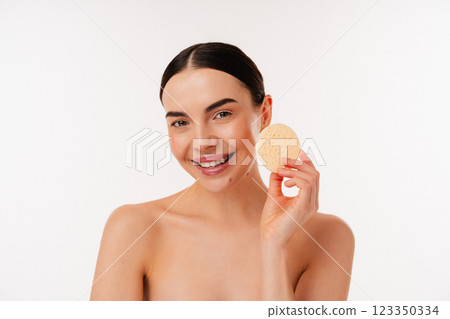 Smiling Woman Demonstrating Natural Skincare Routine With a Facial Sponge Smiling Woman Demonstrating Natural Skincare Routine With a Facial Sponge 123350334