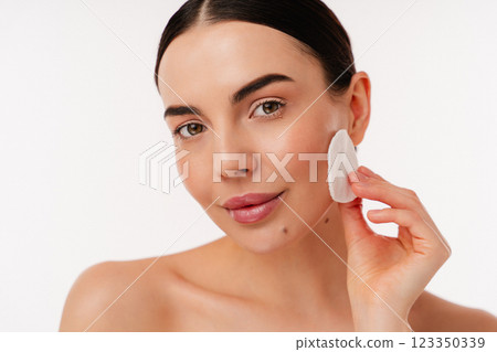 Young Woman Cleansing Her Skin With Cotton Pad in Minimalistic Setting 123350339