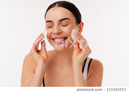 Smiling Woman Cleansing Face With Cotton Pads Using Skin Care Routine 123350353