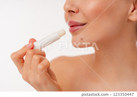 Close-Up of Person Applying Lip Balm for Hydrated Lips and Skincare Routine 123350447