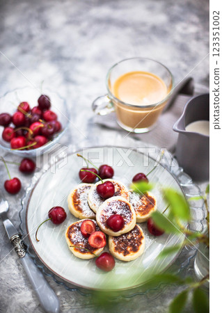 Cottage cheese pancakes with fresh cherry and coffee for breakfast Cottage cheese pancakes with fresh cherry and coffee for breakfast 123351002
