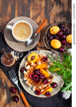 Fresh homemade belgian waffles decorated with cherry, apricot and salted caramel Fresh homemade belgian waffles decorated with cherry, apricot and salted caramel 123351003